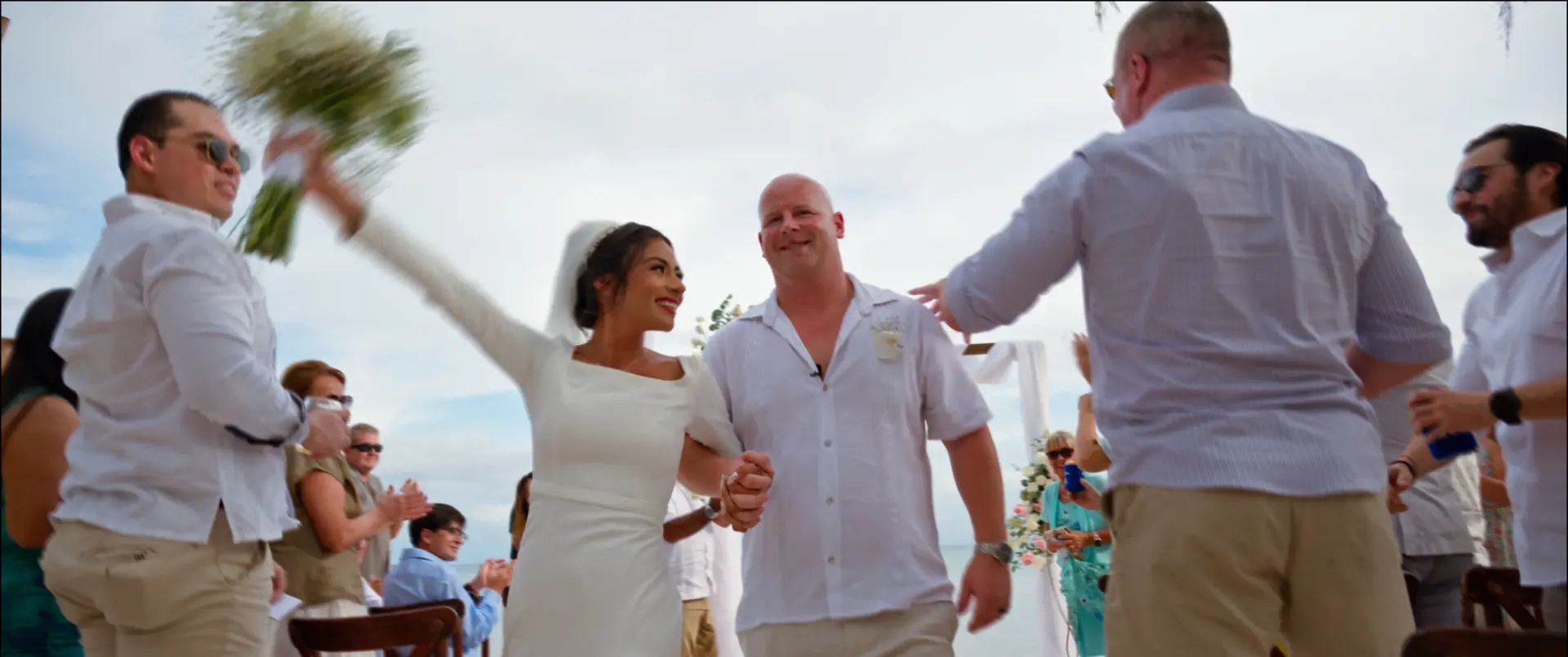 Yanet celebrating with Marc during their beach wedding recessional in Playa del Carmen.