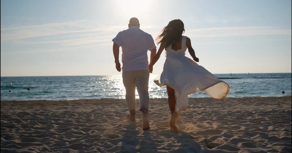 Yanet y Marc corriendo hacia el mar con la luz del final de la tarde en la playa de Playa del Carmen.