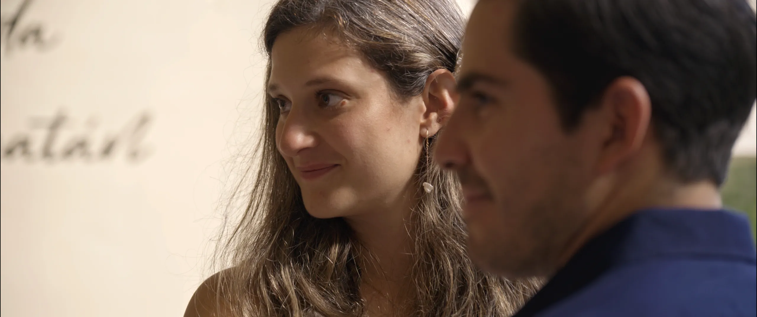 Primer plano espontáneo del perfil de la novia mirando más allá del novio durante la ceremonia.
