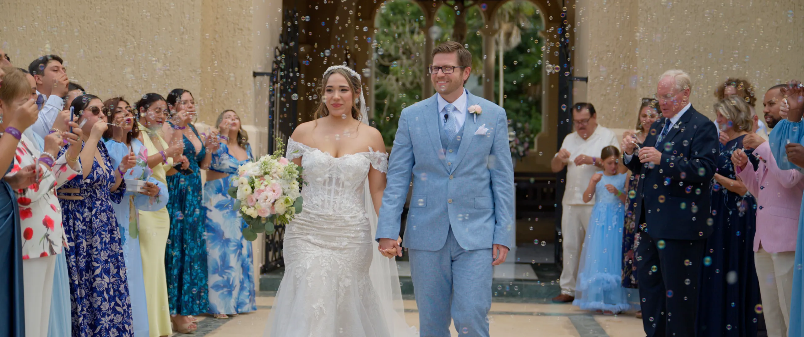 Diana and Zach exiting their chapel ceremony through a bubble tunnel at the Grand Palladium Colonial Resort, an all-inclusive in the Riviera Maya.