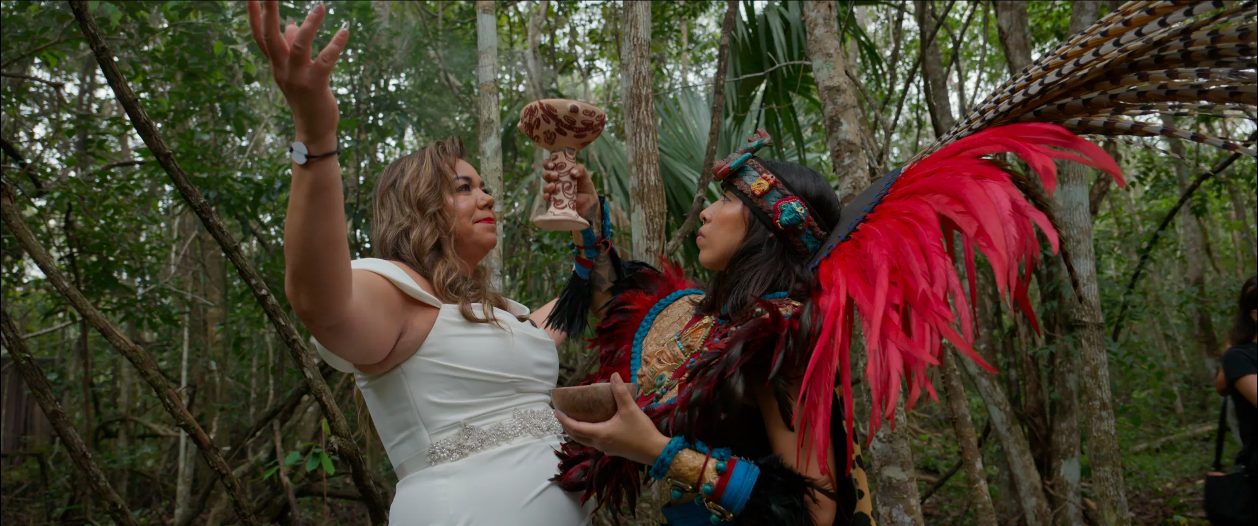 Novia levantando una copa ceremonial durante un ritual de bendición maya tradicional en la selva.